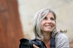 Woman smiling while holding a camera