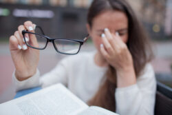 Woman Removing Glasses and Rubbing her Dry Eyes